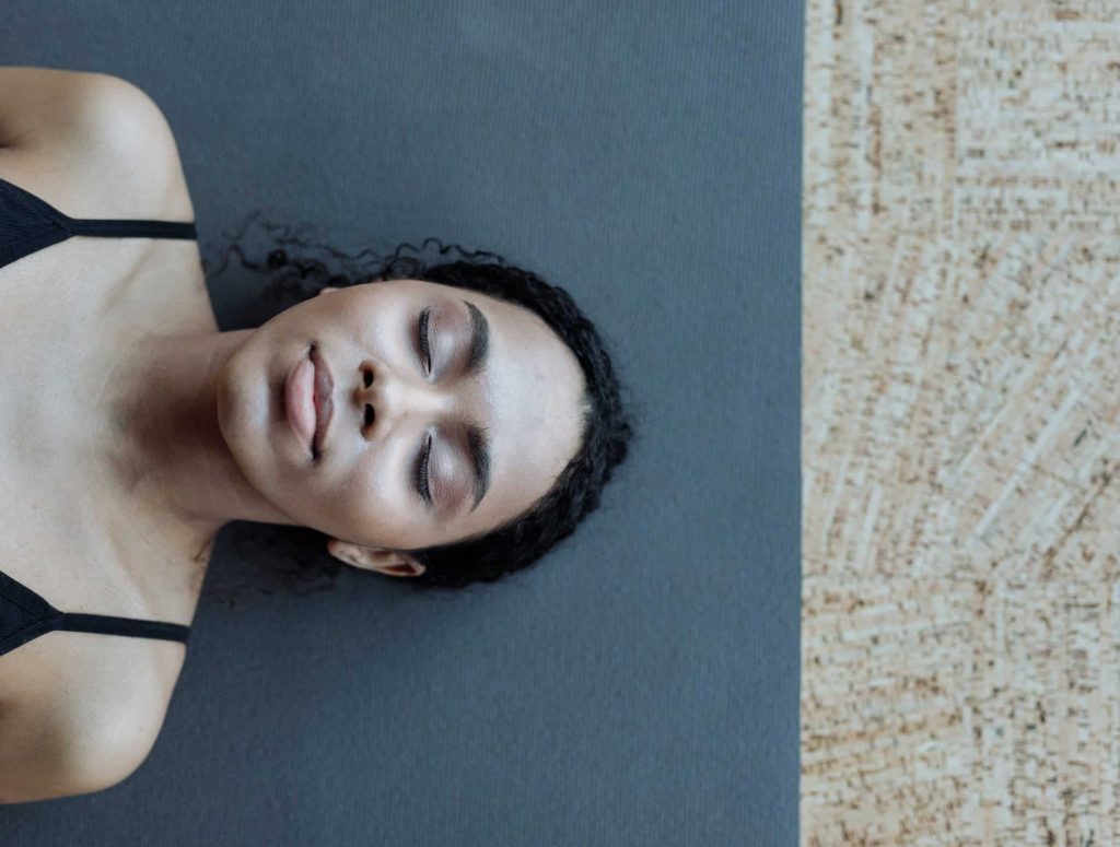 Frau liegt entspannt auf Yogamatte